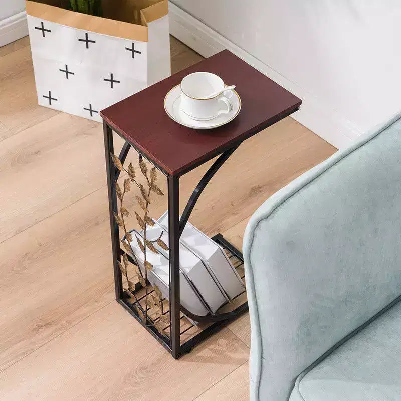 Mesa auxiliar desmontable de una sola capa en forma de C con tablero de densidad marrón, estructura de hierro con recubrimiento de polvo negro y diseño de hoja dorada en pincel