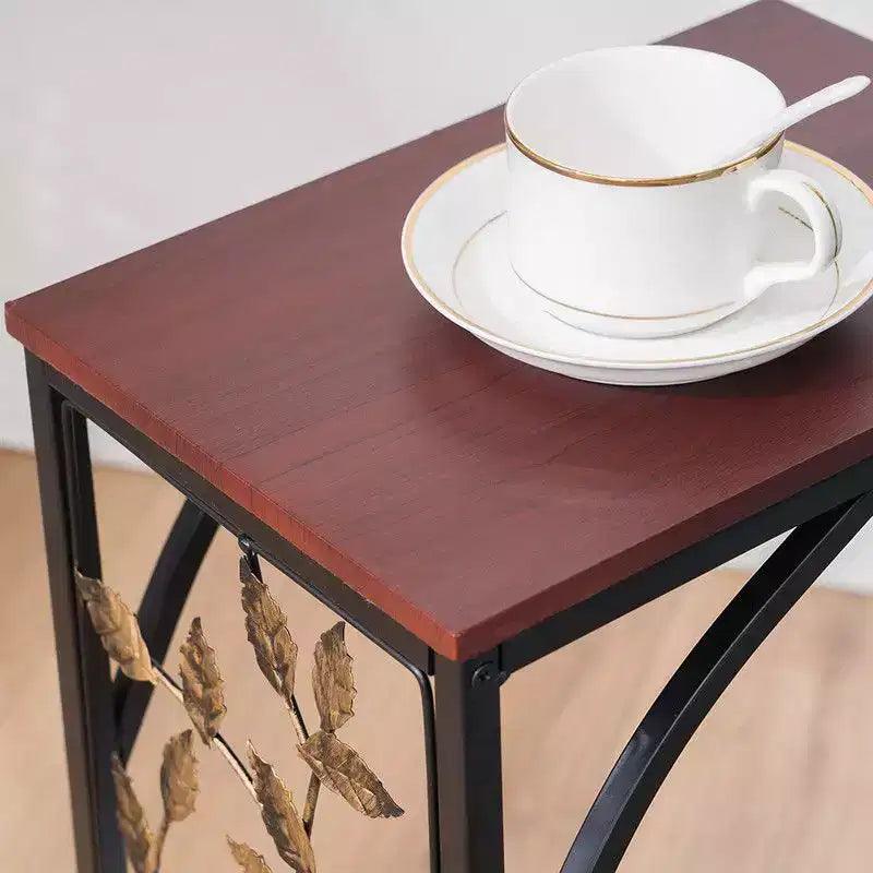 Mesa auxiliar desmontable de una sola capa en forma de C con tablero de densidad marrón, estructura de hierro con recubrimiento de polvo negro y diseño de hoja dorada en pincel